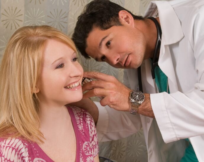 a man helping a woman get ready for a wedding