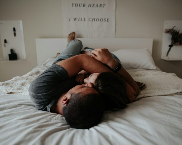 A man and woman cuddling together in bed.