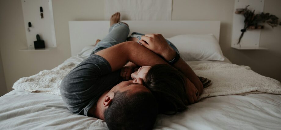 A man and woman cuddling together in bed.