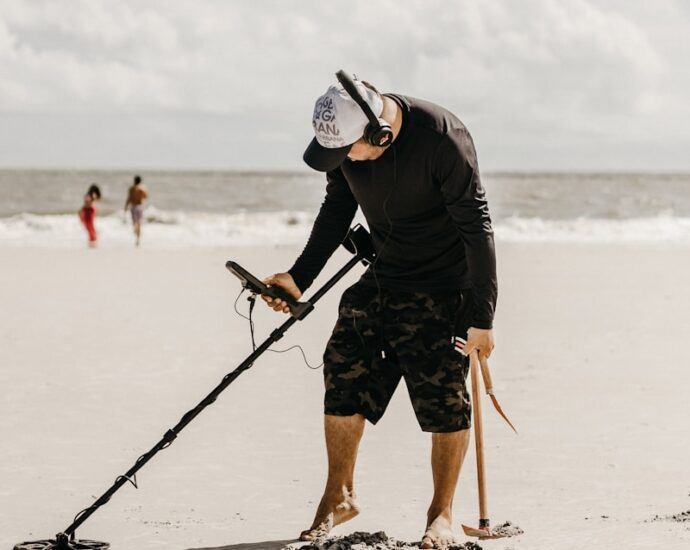 a man holding a stick on the beach