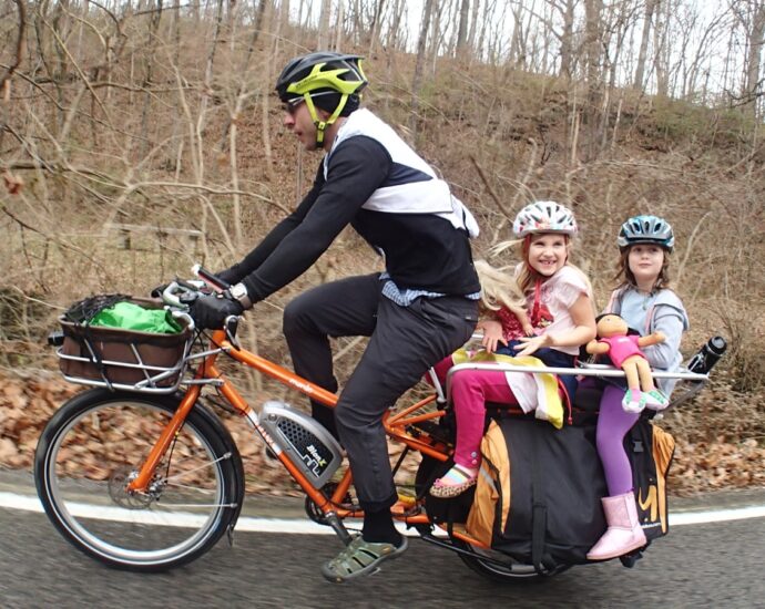 people riding on orange bicycles during daytime